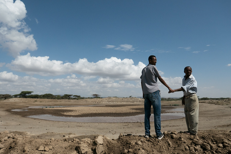Two farmers standing at the nearly dry Wayisso community pond, February 2016